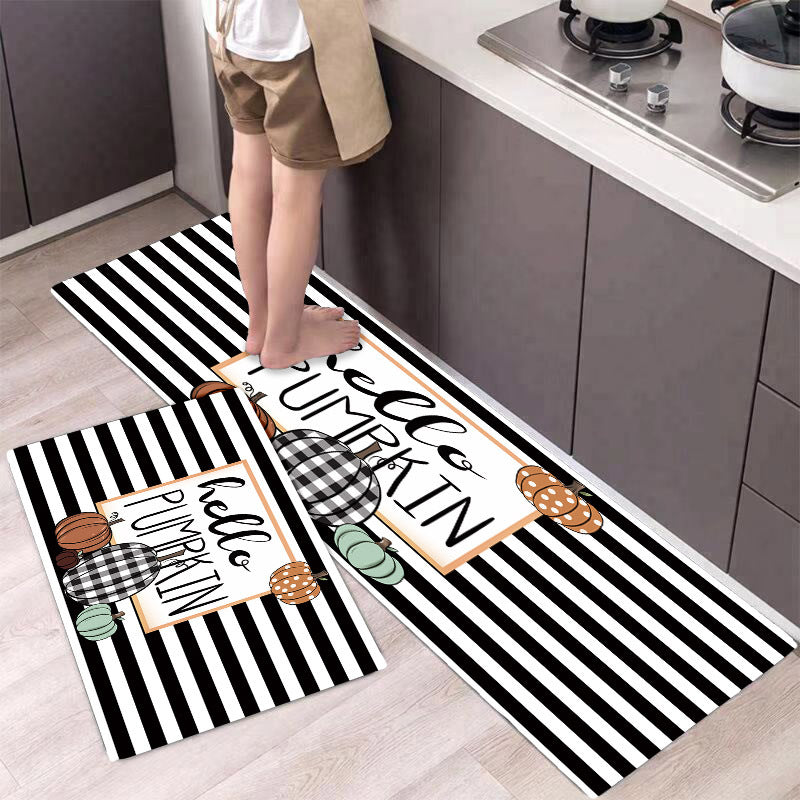 Two Halloween-themed kitchen mats on a floor with a person standing on one of them.