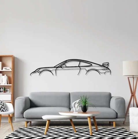 Modern living room with a gray sofa, coffee table, and wall decal of a car.